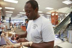 Chief Aviation Boatswain's Mate Hamilton Bryan filling out form before selecting chief uniforms aboard USS Abraham Lincoln