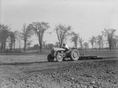 Farmer loosening earth with tractor and cultivator in LaSalle farm