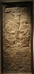 Kalvariesten limestone medieval stone depicting crucifixion with Mary and John, at Stockholm Medeltidsmuseum