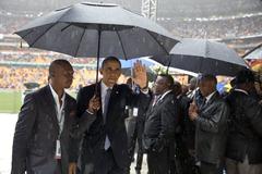President Obama walking off soccer stadium field in the rain after remarks