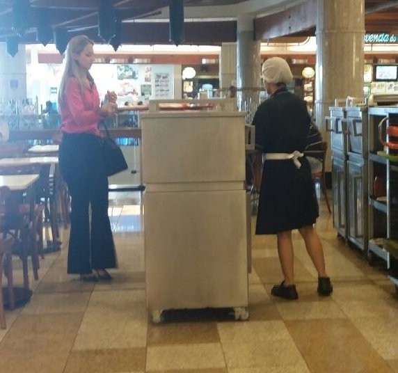 Cleaning lady cleaning food trays at Bourbon Shopping mall in São Paulo