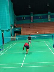 Bird's eye view of a badminton court with nets and boundary lines