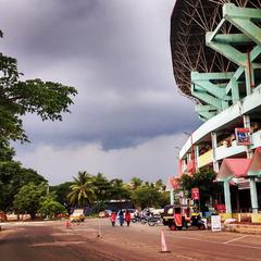 Exterior view of International Stadium Kaloor with red and white facade and green surroundings