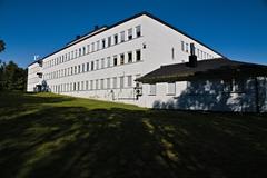 Exterior view of Tromsø Museum building surrounded by trees under a blue sky