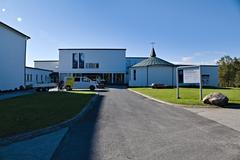 Tromsø Museum building surrounded by trees under a blue sky