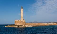 Chania lighthouse on a rocky shore at sunset in Crete Greece