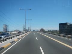 View of South Luzon Expressway and Metro Manila Skyway from front bus window showing elevated highways and city buildings