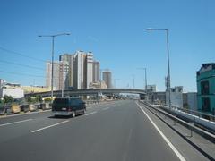 Elevated South Luzon Expressway and Metro Manila Skyway interchange at San Isidro, Makati City with multi-level roadways and urban cityscape under clear sky