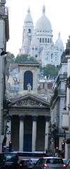 View of Notre-Dame-de-Lorette church in the foreground and Sacré-Cœur Basilica in the background from rue Laffitte, Paris