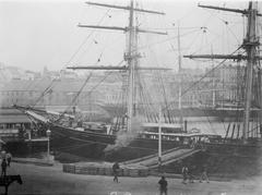 The clipper ship Cutty Sark docked in a port with masts and rigging visible