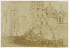 View of the elevation of the cloister wall on the Place de la Claustre with the Périgueux Cathedral in the background and stone piles in the foreground