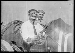 Portrait of André Boillot standing beside a Talbot automobile during the weighing at the Grand Prix de l'A.C.F. at Le Mans in 1921