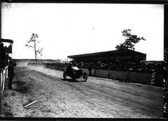 1920 cyclecar race at Circuit de la Sarthe with driver Leveque on Ruby car racing in front of grandstands