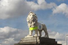 Stone lion sculpture in London with Guide Dogs for the Blind charity advertisement