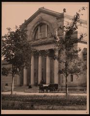 Black and white vertical photograph of the St. Louis Art Museum with horse-drawn carriage and group of people