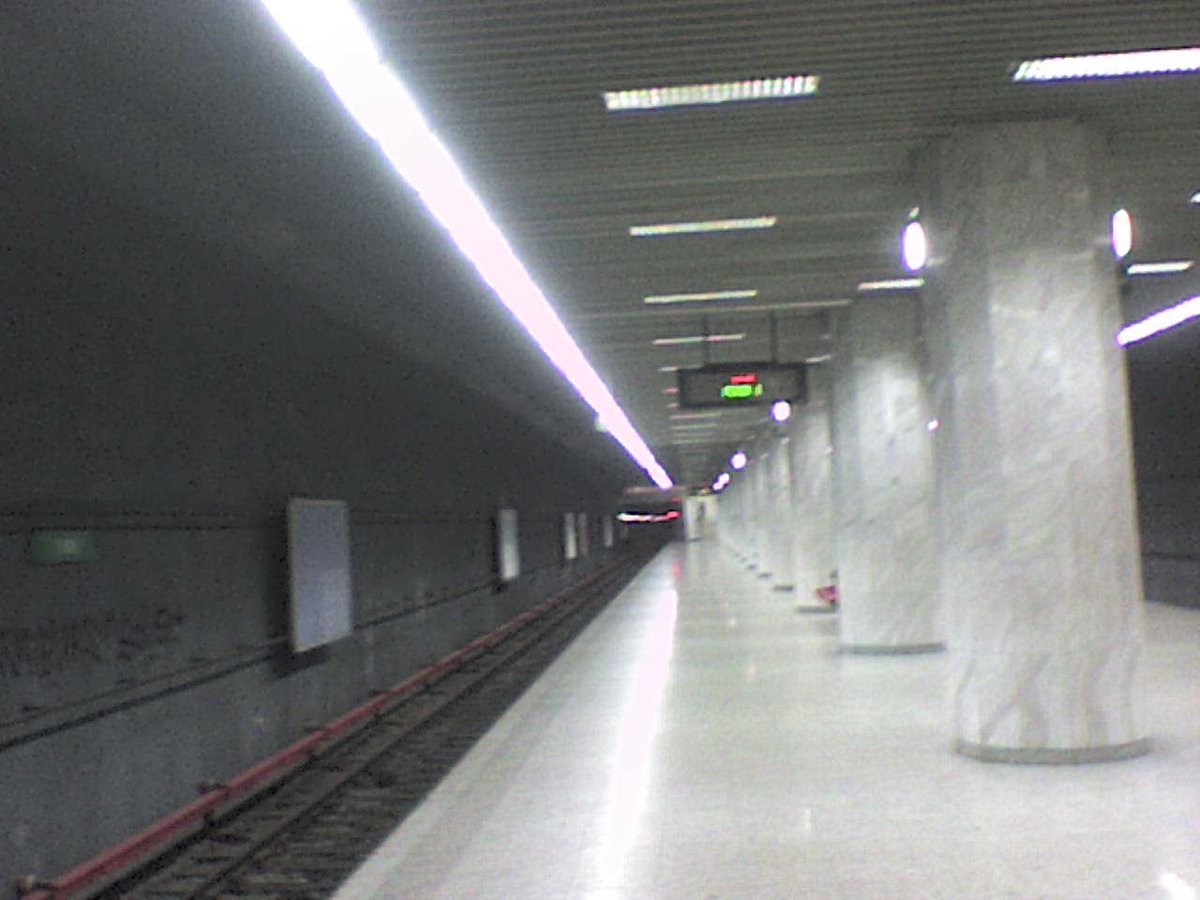 Mai Station in Japan with overhead railway tracks and urban buildings