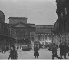 Street view of Ul. Miodowa in Warsaw showing war damages, St. Anne's Church and trams number 3 and 4