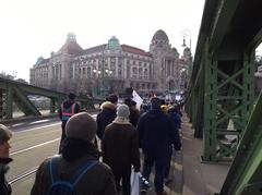 Protesters marching on Szabadság Bridge in Budapest against the overtime work act with tram passing by