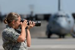 U.S. Air Force photojournalist documenting a C-130 Hercules aircraft at Yokota Air Base