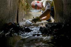 Airman shoveling mud from irrigation system after flood in Kanuma City, Japan