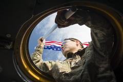 Staff Sgt. Brian Wright holding U.S. flag outside C-130 Hercules during 2015 Japanese-American Friendship Festival at Yokota Air Base