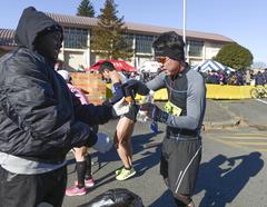 Military dog trainer hands fruit to runner after Frostbite Run at Yokota Air Base