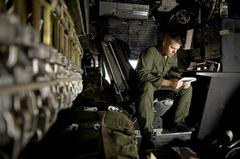 US Air Force Staff Sgt. Curtis Hornbeak reviewing flight operations guide at Yokota Air Base before Sendai supply flight