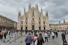 Cathedral of Milano exterior with intricate Gothic architecture and spires under bright blue sky