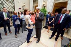 U.S. Secretary of State John Kerry playing with a child after addressing U.S. Mission employees in Brussels