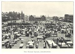 Historical black and white photograph of Market Square in Johannesburg with horse-drawn carriages and early 20th-century buildings