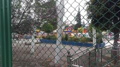 Empty amusement park with a closed roller coaster and vacant walkways