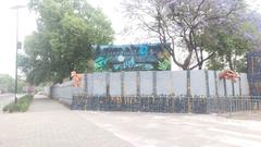 Entrance gate of the closed Feria de Chapultepec amusement park with colorful signage and trees in background