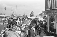 Black and white photograph of the sculpture group David, Goliath, and the shield bearer being transported by a truck from the Waaggebouw to the Historical Museum in Kalverstraat, Amsterdam, on September 20, 1969