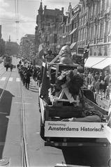 Black and white photo of the sculpture group David, Goliath, and squire being transported on a truck from Waag building to Historical Museum on Kalverstraat Amsterdam on 20 September 1969