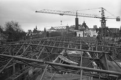 Black and white photo of a construction site with a crane removing the roof covering of the Amsterdam Historical Museum in December 1973