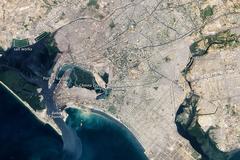True-color satellite image of Karachi, Pakistan showing southwestern city edges with mangroves, river deltas, ports, and urban areas
