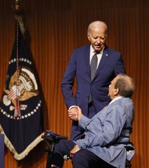 President Joe Biden delivering the keynote address at LBJ Presidential Library in Austin, Texas with Ambassador Andrew Young seated beside him