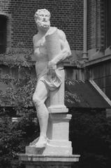 Black and white photo of a man standing in a garden during summer