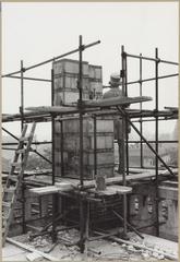 Sculpture of a stonemason by a small wall surrounded by scaffolding at Rembrandt extension restoration