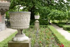 Sculptures of vases on pedestals in a garden, captured in a photograph from June 2003