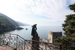 Statue of Saint Francis of Assisi with the Wolf of Gubbio overlooking the blue sea in Monterosso al Mare