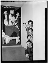 Black and white portrait of six jazz arrangers Ralph Burns, Edwin A. Finckel, George Handy, Neal Hefti, Johnny Richards, and Eddie Sauter posing at the Museum of Modern Art, New York, March 1947