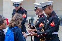U.S. Marine Corps saxophone player signing pamphlet at Les Invalides, Paris