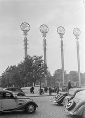 Poles with symbols at the French Pavilion with automobile traffic at the 1937 World's Fair in Paris