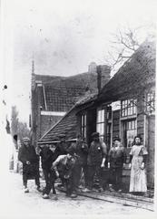 Historical photograph of Buikslotermeerdijk and Meerweg in Amsterdam from 1910 to 1915 showing a blacksmith's workshop next to the Hervormd Weeshuis orphanage