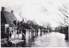 Black and white photo of a blacksmith shop flooded in 1916 at Meerweg, Buikslotermeerdijk, Amsterdam, featuring Jacob Sluis, Pieter Sluis, and a village carpenter and announcer
