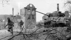 American soldiers of Task Force Baum running past a destroyed Sherman tank in Aschaffenburg