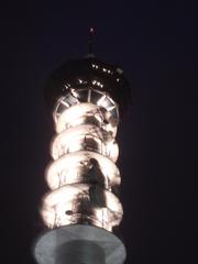 Tyholt broadcast tower in Trondheim illuminated at night with restaurant
