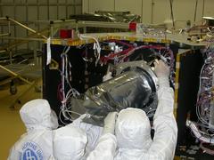 Technicians installing Long Range Reconnaissance Imager LORRI on NASA New Horizons spacecraft at Johns Hopkins University Applied Physics Laboratory