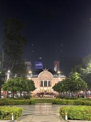 Front view of Saigon Opera House at night with illuminated archways and columns
